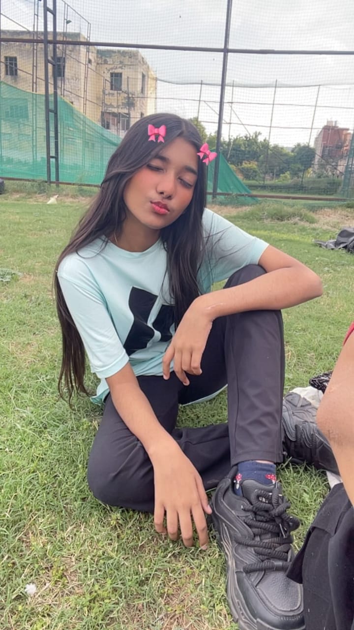 Kamya sitting on the grass with hair bows